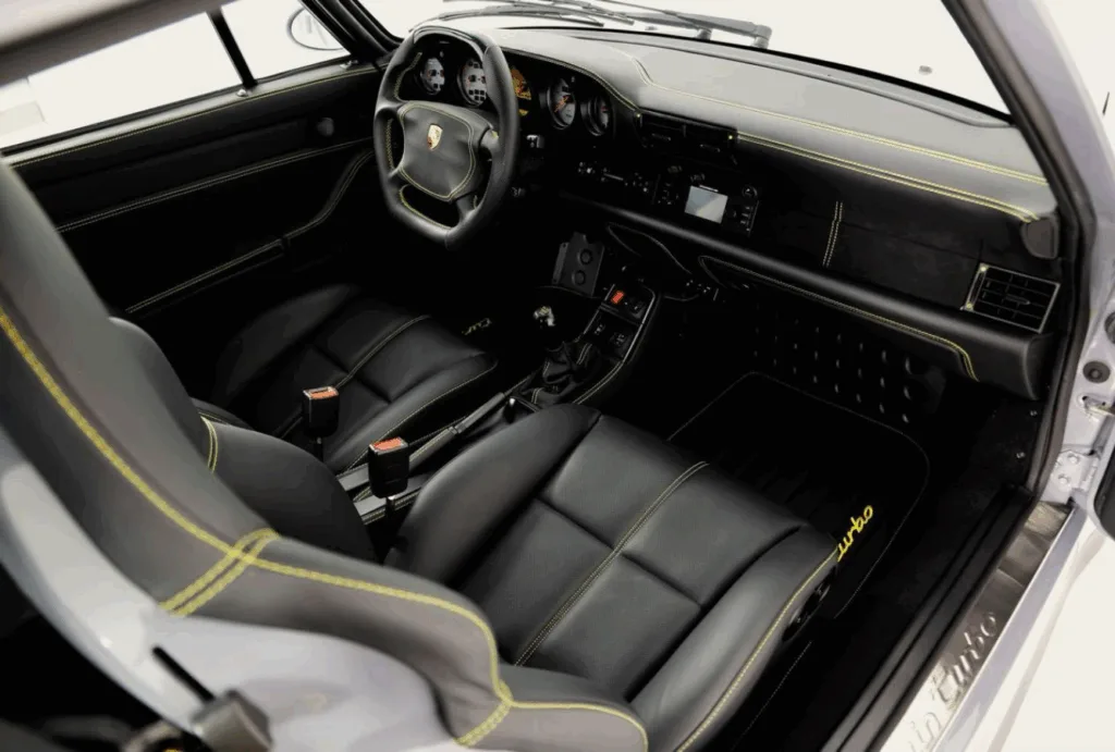 Luxury car upholstery with custom black leather and yellow stitching in a Porsche interior